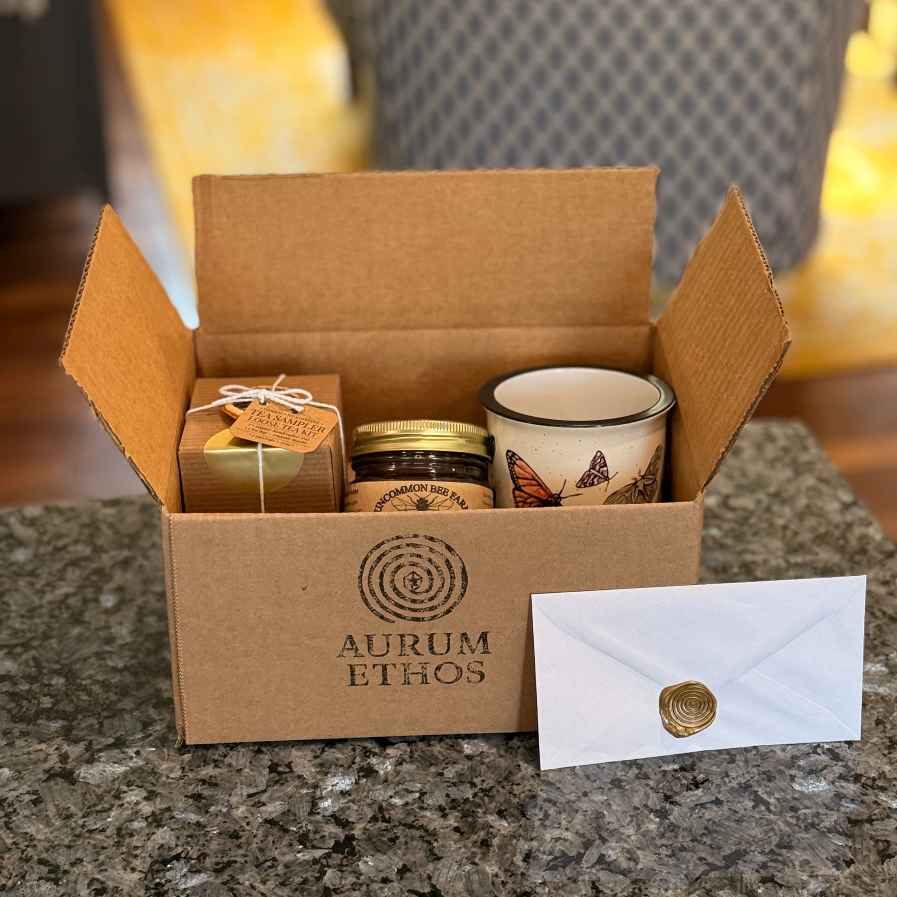 Slow Mornings Basic Story Box with tea, honey, and a handmade mug with butterflies on it.